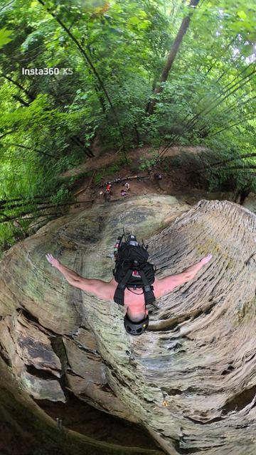 Looking down from high on a sandstone climb, arms out