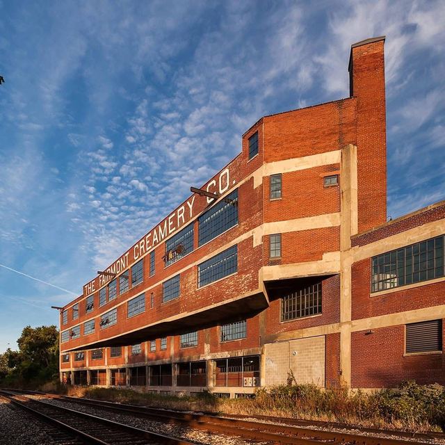 The old Fairmont Creamery building in golden light beside the railroad tracks